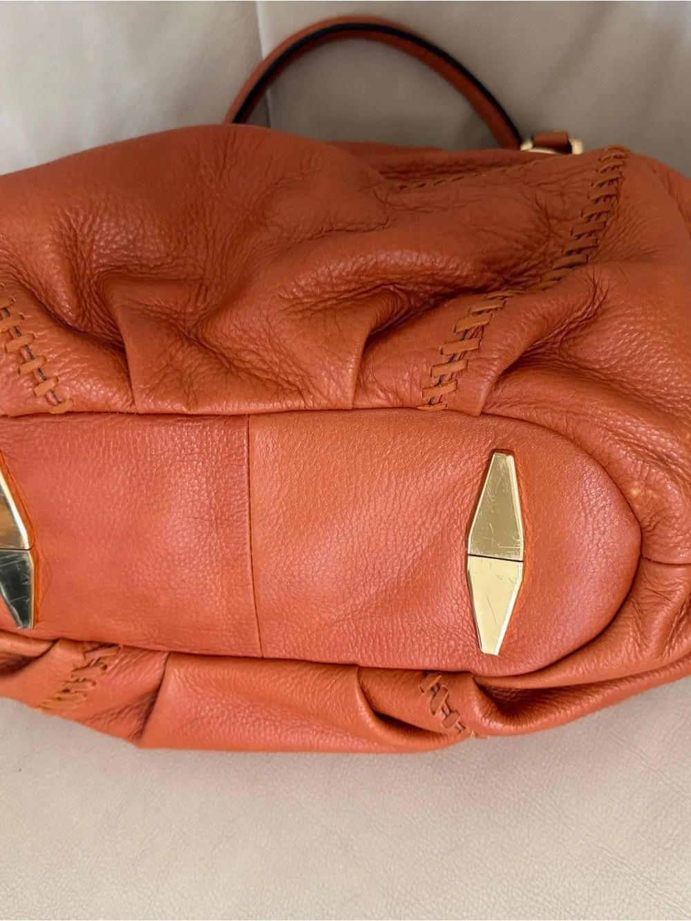 Orange leather handbag appears to be a slouchy style by orYany